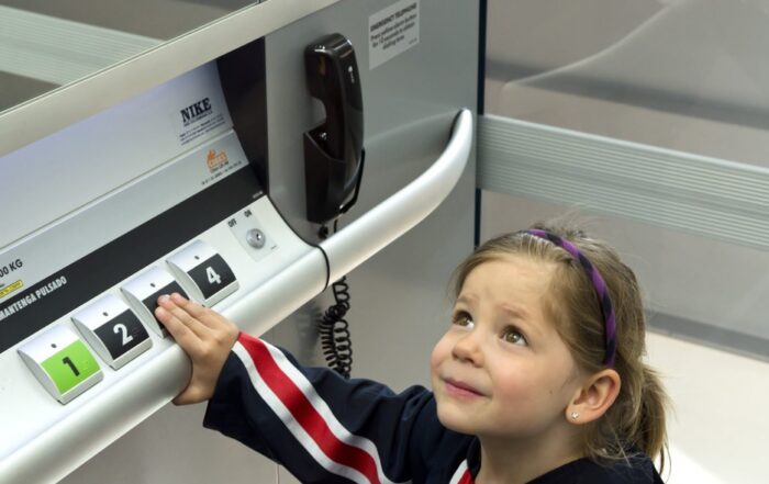 youg girl using Cibes Lift pressing on button in a school